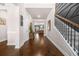 Inviting foyer with hardwood floors, a staircase featuring decorative trim, and an open view to the living room at 6441 Oakhurst Pl, Fairburn, GA 30213