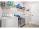 Convenient laundry room with washer, dryer, overhead shelving, and ample storage space at 6441 Oakhurst Pl, Fairburn, GA 30213