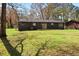 View of the backyard of a cozy home with large grassy area and mature trees at 8212 Englewood Trl, Riverdale, GA 30274