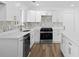 This kitchen has stainless steel appliances, white cabinets, and luxurious quartz countertops at 8212 Englewood Trl, Riverdale, GA 30274