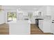 Well-lit kitchen boasts white cabinets, an island, and modern appliances for a clean and stylish look at 8212 Englewood Trl, Riverdale, GA 30274