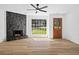 Spacious living room with stone fireplace, wood floors, and large windows offering natural light at 8212 Englewood Trl, Riverdale, GA 30274