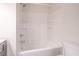 Bathroom with tub and white tile enclosure with mounted shower head and silver fixtures at 2090 Sand Wedge Nw Cir, Kennesaw, GA 30144