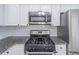 Close-up of a kitchen with granite countertops and stainless steel microwave and stove at 2090 Sand Wedge Nw Cir, Kennesaw, GA 30144