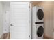 Convenient laundry room with stacked washer and dryer and adjacent white panel door at 1080 Peachtree Ne St # 2005, Atlanta, GA 30309