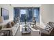 Bright living room with floor-to-ceiling windows showcasing city views, complemented by stylish modern furniture at 1080 Peachtree Ne St # 2005, Atlanta, GA 30309