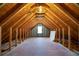 Spacious attic with exposed wooden beams, plywood subfloor, and a window for natural light at 1129 Annie Sw Ln, Mableton, GA 30126