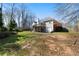 Large backyard with mature trees and a glimpse of the deck and patio at 1129 Annie Sw Ln, Mableton, GA 30126