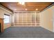 Basement with a custom built-in wall of shelving and wood panel ceiling, ready for personalized uses at 1129 Annie Sw Ln, Mableton, GA 30126