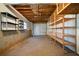 Unfinished basement with concrete floor, shelving units, and a garage door for storage at 1129 Annie Sw Ln, Mableton, GA 30126