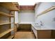 Unfinished basement offering a utility sink, work area, and wooden shelving for organized storage solutions at 1129 Annie Sw Ln, Mableton, GA 30126