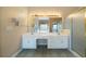 Bright bathroom features a double vanity with two sinks, large mirror, and a glass shower enclosure at 1129 Annie Sw Ln, Mableton, GA 30126