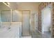 Bathroom featuring double sinks, a shower with a glass door, tile flooring, and ornate wallpaper at 1129 Annie Sw Ln, Mableton, GA 30126