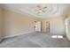 Spacious bedroom featuring a tray ceiling with fan, neutral carpeting, and multiple doorways at 1129 Annie Sw Ln, Mableton, GA 30126