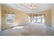 Bright bedroom with large windows, a tray ceiling with fan, and neutral carpeting at 1129 Annie Sw Ln, Mableton, GA 30126