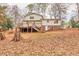 View of a two-story home with a wooden deck, stairs, and a landscaped backyard at 1417 Hickory Sw Dr, Lilburn, GA 30047