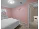 Cozy bedroom featuring pink walls, a white bed frame, and a dresser with oval mirror at 1417 Hickory Sw Dr, Lilburn, GA 30047