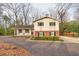 Inviting two-story home with dark shutters and a cozy front porch with seating at 1417 Hickory Sw Dr, Lilburn, GA 30047