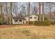 Beautiful two-story home featuring a charming front porch and mature trees surrounding the property at 1417 Hickory Sw Dr, Lilburn, GA 30047