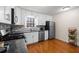 Well-lit kitchen with stainless steel appliances, sleek countertops, hardwood flooring, and ample storage at 1417 Hickory Sw Dr, Lilburn, GA 30047