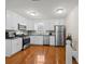 Modern kitchen with white cabinets, stainless steel appliances, granite countertops, and hardwood floors at 1417 Hickory Sw Dr, Lilburn, GA 30047