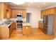 Bright kitchen features stainless steel appliances, island, granite countertops, and wood floors at 2335 Corbett Ct, Powder Springs, GA 30127