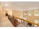 Hallway overlooking the living room featuring hardwood floors, wrought iron banister, and an abundance of windows at 3928 Herron Sw Ln, Atlanta, GA 30349