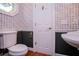 Charming half-bathroom features floral wallpaper, stylish fixtures, and wainscoting for a touch of elegance at 7364 N Mitchell N Ct, Villa Rica, GA 30180