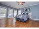 A bright bedroom with hardwood floors, plenty of windows, and a door leading to an outdoor patio or deck at 7364 N Mitchell N Ct, Villa Rica, GA 30180