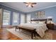 A spacious main bedroom with a seating area, a beautiful decorative headboard, and windows to the outside at 7364 N Mitchell N Ct, Villa Rica, GA 30180