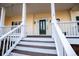 Covered front porch showcasing white columns, dark wood floors, and a stylish front door at 7364 N Mitchell N Ct, Villa Rica, GA 30180