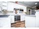 Bright kitchen featuring white cabinets, a stylish backsplash, stainless steel appliances, and hardwood floors at 7364 N Mitchell N Ct, Villa Rica, GA 30180