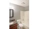 This bathroom features a white tub and toilet, brown vanity with a sink, and gray walls at 1946 Taffeta Trl, Lithonia, GA 30058