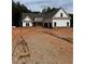 New construction home with white siding, brick accents, and an attached two car garage at 215 Pinewood Dr, Covington, GA 30014