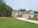 Spacious newly built home featuring a three-car garage, manicured lawn and professional landscaping at 215 Pinewood Dr, Covington, GA 30014