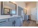 Main bathroom featuring dual sink vanities with modern mirrors and lighting and walk in shower at 215 Pinewood Dr, Covington, GA 30014