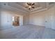 Spacious main bedroom features plush carpeting, a tray ceiling with fan, and double doors to the main bath at 215 Pinewood Dr, Covington, GA 30014