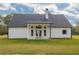 Charming rear exterior showcasing a modern farmhouse design with white siding and a covered patio at 215 Pinewood Dr, Covington, GA 30014