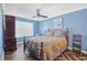 Comfortable bedroom featuring blue walls, ceiling fan, and wood-look herringbone floors at 2411 Heritage Park Nw Cir # 14, Kennesaw, GA 30144
