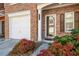 Close-up of townhome entrance with attached garage, featuring colorful landscaping at 2411 Heritage Park Nw Cir # 14, Kennesaw, GA 30144