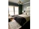 Cozy bedroom featuring hardwood floors, two windows, neutral bedding, and a decorative rug at 1670 Rogers Sw Ave, Atlanta, GA 30310