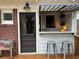 Outdoor bar with glass-paneled awning, bar stools, brick detail and Coca-Cola Ice Chest at 1670 Rogers Sw Ave, Atlanta, GA 30310