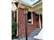 Detailed exterior view of the brick facade, lantern, steps, and front door at 1670 Rogers Sw Ave, Atlanta, GA 30310