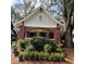 Charming brick home with beautiful landscaping, a welcoming arched porch, and mature trees at 1670 Rogers Sw Ave, Atlanta, GA 30310