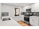 Modern kitchen featuring stainless steel appliances, white cabinets, and grey backsplash at 195 Sailwind Ct, Roswell, GA 30076