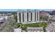 Luxury high-rise condo building featuring balconies, a rooftop pool, and mature landscaping at 2700 Paces Ferry Se Rd # 302, Atlanta, GA 30339