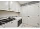 Laundry room featuring a washer, dryer, and ample storage in white cabinets at 2700 Paces Ferry Se Rd # 302, Atlanta, GA 30339