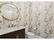 Charming powder room featuring elegant wallpaper, a round mirror, and marble countertops at 2700 Paces Ferry Se Rd # 302, Atlanta, GA 30339