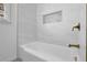 Modern tub shower with white subway tile, a gold shower head, and a built-in niche at 965 Carr Nw St, Atlanta, GA 30318