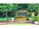 The Woodlands community entrance with stone signage surrounded by colorful landscaping, trees, and green lawns at 271 Balaban Cir, Woodstock, GA 30188